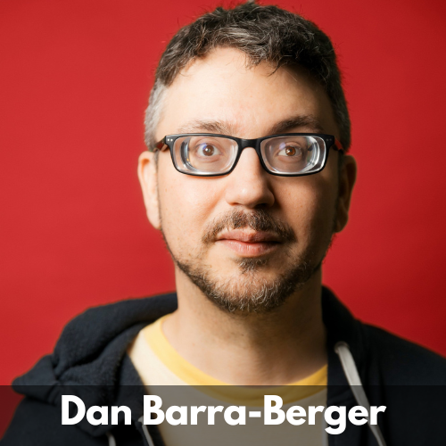 Dan Barra-Berger is a white man in his 30s. He has short brown hair with a touch of grey, a moustache and short beard. He wears black rimmed glasses and a t-shirt under a zip up sweatshirt.